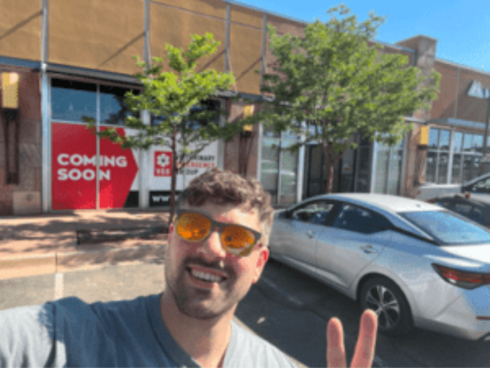 A VEG employee takes a selfie in front of a VEG ER for Pets hospital.