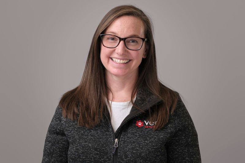 A smiling Dr. Sonya Hanson smiles, wearing glasses, a VEG jacket and white shirt.