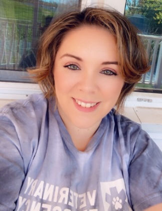 Veterinary nurse in smiling in company purple shirt