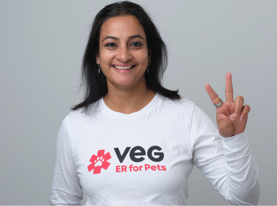 Anusha Balakrishnan, Director, Emergency Certification Education at VEG ER for Pets smiles at the camera while making the victory sign with her fingers