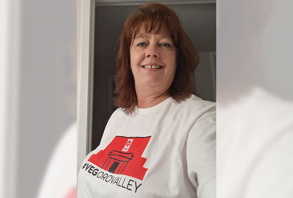 Woman with red hair and white VEG shirt smiles for camera