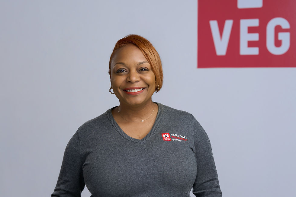 Smiling woman with red hair in gray veterinarian scrubs 