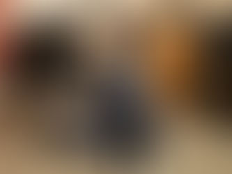 An older dog with signs of dementia is hugged by a veterinarian sitting cross-legged on the floor. 