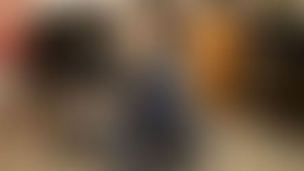 An older dog with signs of dementia is hugged by a veterinarian sitting cross-legged on the floor. 