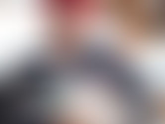 A white and black dog is being cared for by a veterinarian wearing glasses