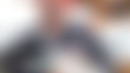 A white and black dog is being cared for by a veterinarian wearing glasses