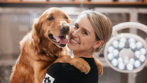 A veterinarian gets a hug from a golden dog