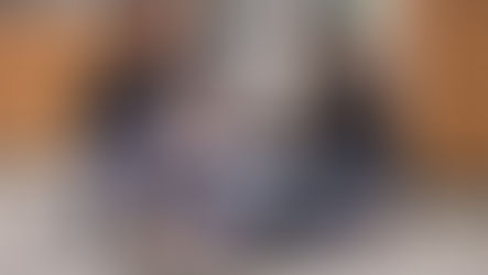 A dog with excessive sneezing is see by two vets siting on the floor