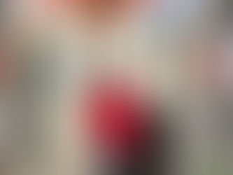 A VEG employee in a red jacket and black had gives a V sign with their fingers to the camera. 