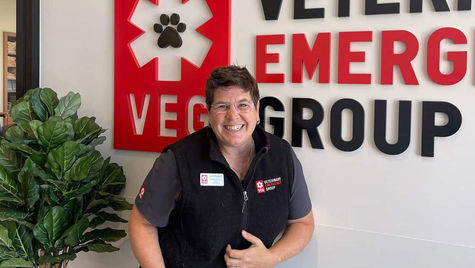 A VEG doctor smiling at the camera, wearing scrubs and a black fleece vest.