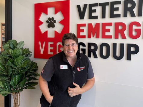 A VEG doctor smiling at the camera, wearing scrubs and a black fleece vest.