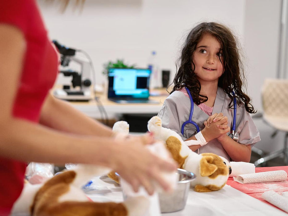 Little vet participant working with a dog stuffed animal