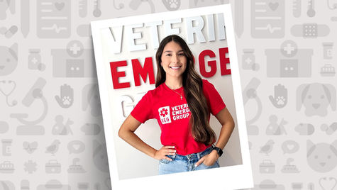 ER doctor in a red shirt smiling at the camera.